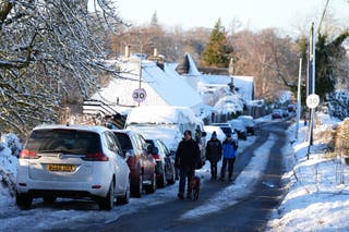 People walk through the snow in Balerno, Edinburgh on Friday